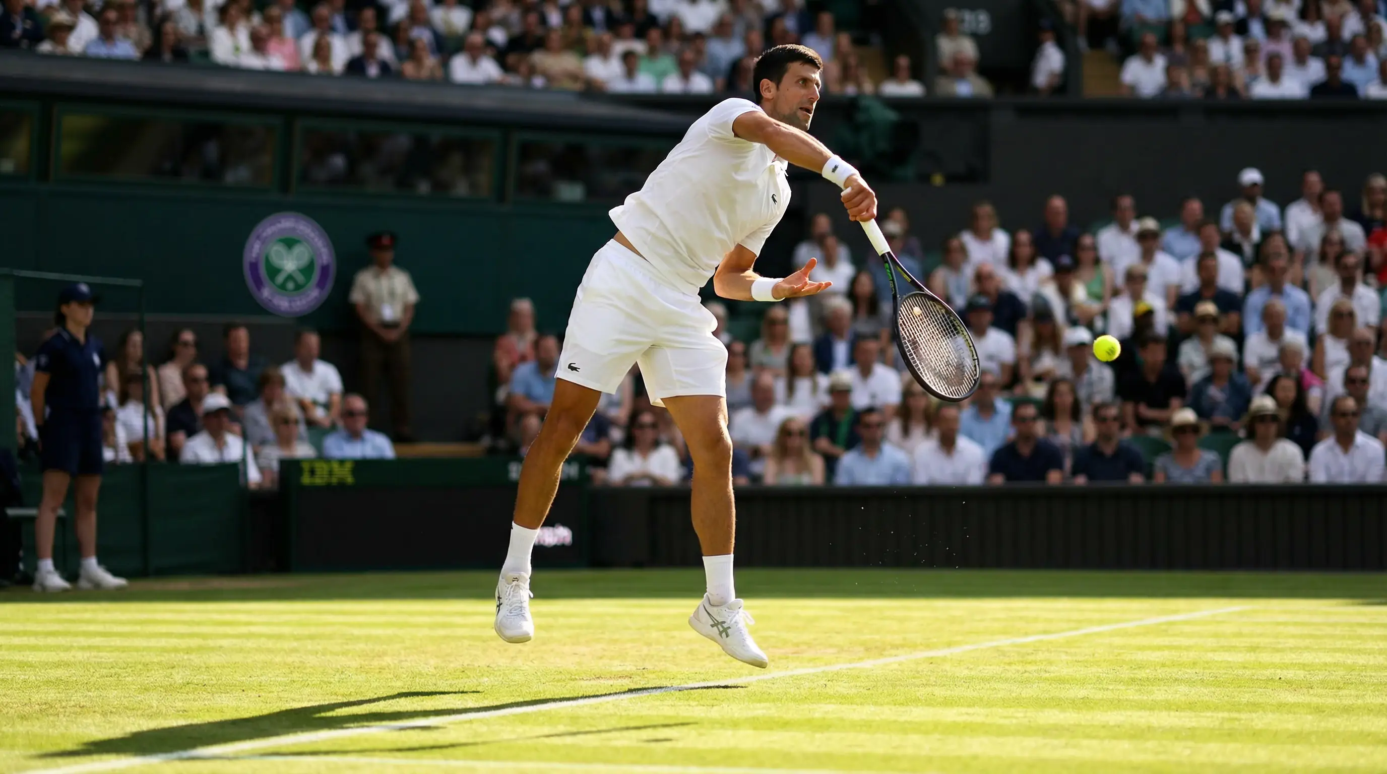 Tennisspieler auf dem Rasenplatz von Wimbledon beim kraftvollen Aufschlag mit dem ikonischen grünen Court im Hintergrund